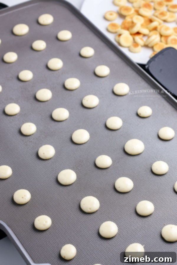 Micro Flapjack Bites 19 Mini pancake cereal cooking on a griddle, showing the preparation process.