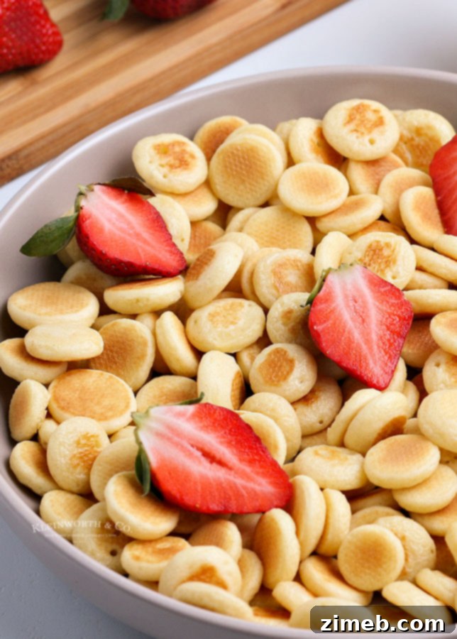 Micro Flapjack Bites 20 A large serving of mini pancake cereal in a bowl with various toppings.