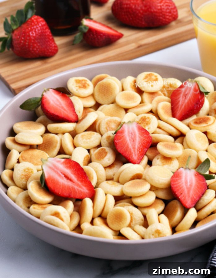 Micro Flapjack Bites 3 Mini Pancake Cereal served with fresh strawberries, enhancing its appeal.