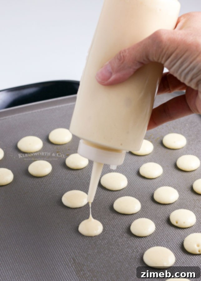 Micro Flapjack Bites 7 Close-up of batter being squeezed onto a griddle to create mini pancake cereal.