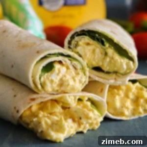 Four egg salad spinach wraps stacked on each other . Setting on a slate board.