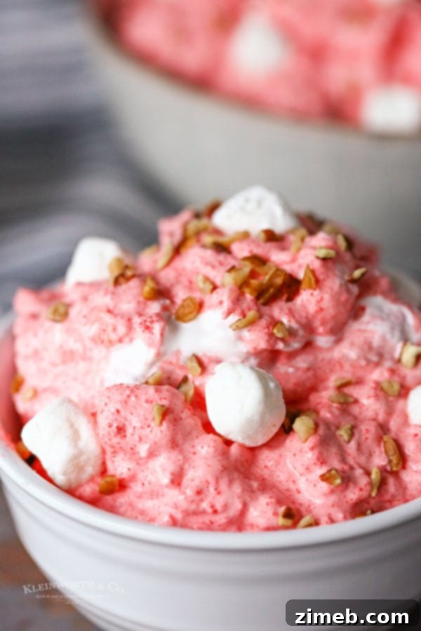 A close-up of Raspberry Jello Salad, showing its vibrant color and fluffy texture.