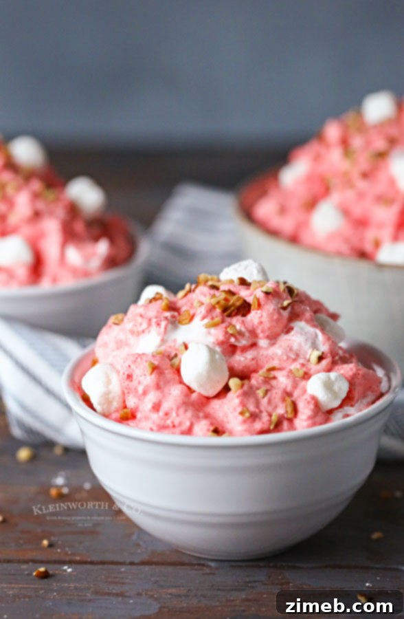 A serving of creamy cool whip jello salad in a glass bowl.