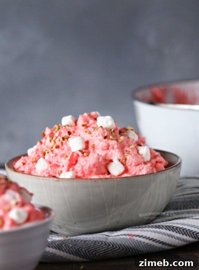 A bowl of cottage cheese salad with strawberries and mini marshmallows.