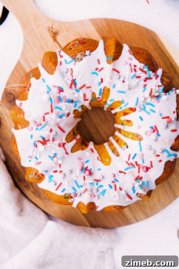 Close-up of a festive 4th of July Bundt Cake adorned with red, white, and blue sprinkles and a simple glaze.