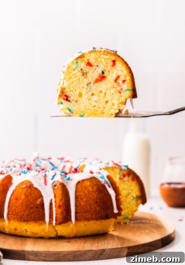 A perfectly baked slice of 4th of July Bundt Cake, showcasing its moist texture and colorful funfetti sprinkles.