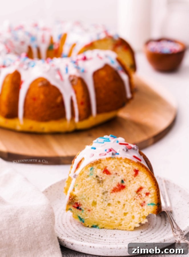Beautifully glazed 4th of July Bundt Cake, garnished with extra sprinkles, ready to be served as a holiday dessert.