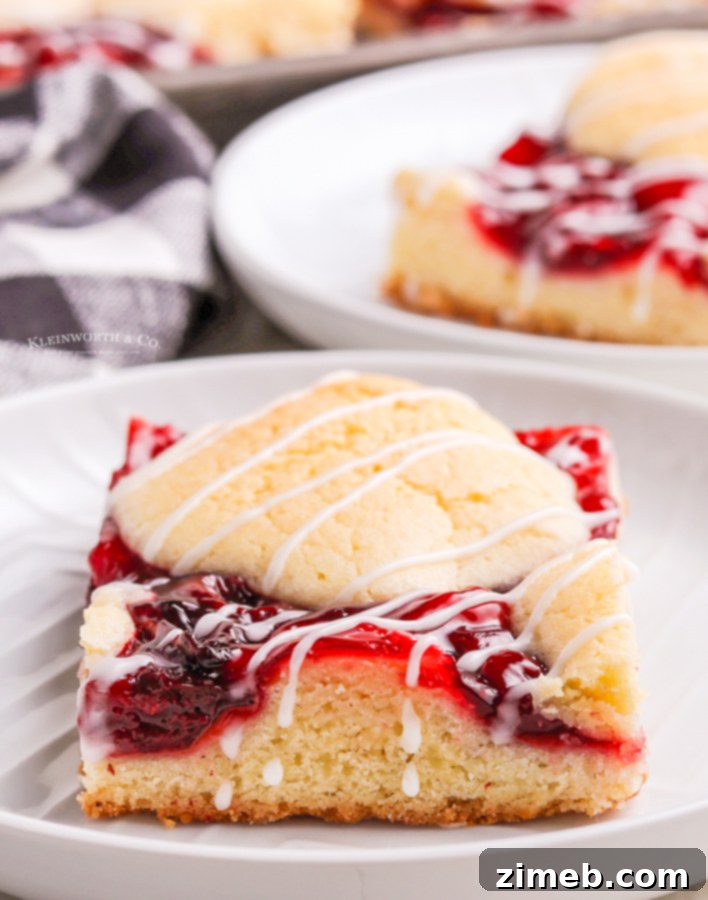 Ruby Red Cherry Squares 8 Best cherry pie bars cut into squares, beautifully showing the layers of cake and fruit filling, topped with glaze.