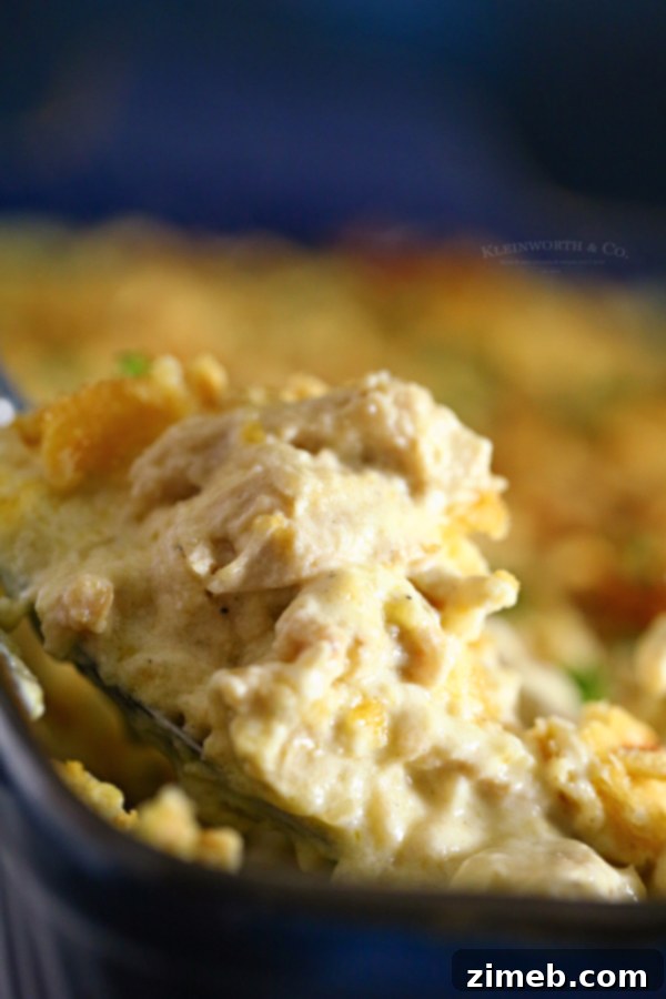 A large serving of Ritz Cracker Chicken Casserole on a white plate, garnished with fresh herbs.