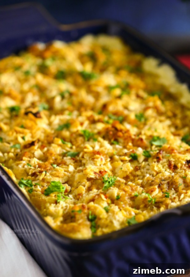 A serving spoon lifting a portion of creamy Ritz Cracker Chicken Casserole, showcasing the tender chicken and golden cracker topping.