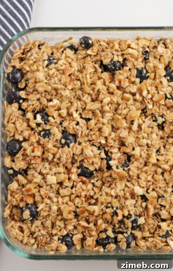 Warm Blueberry Oat Bake 8 A 9x9 inch baking dish filled with unbaked oatmeal mixture, neatly spread and ready for baking, showcasing the smooth surface and potential for toppings.