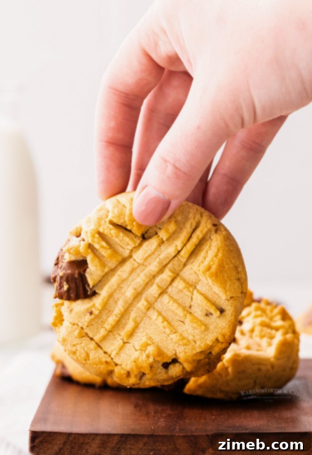 Peanut Butter Cup Stuffed Cookies 8 Freshly baked Reese's cookies on a baking sheet, featuring a delightful texture.