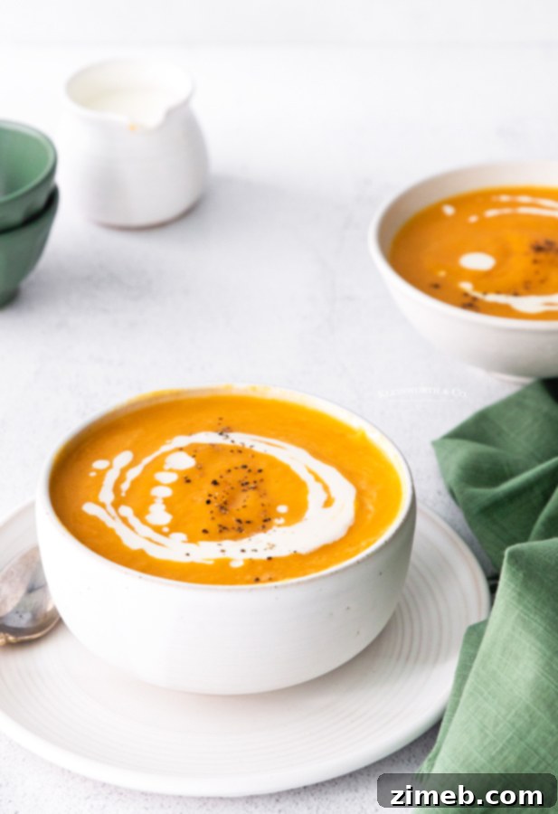 Velvety Instant Pot Butternut Squash Soup 23 Fall Squash Soup - A cozy autumnal scene featuring a bowl of butternut squash soup, surrounded by seasonal decor like small pumpkins and fall leaves, evoking warmth and harvest flavors.