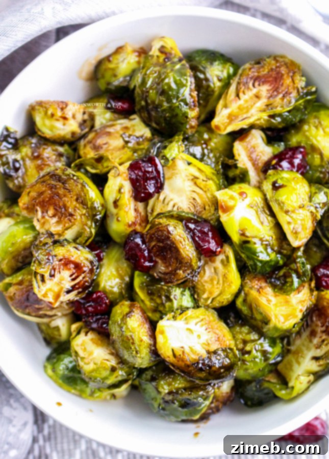 Sticky Sweet Balsamic Brussels 3 A vibrant bowl of roasted Brussels sprouts with balsamic glaze and dried cranberries, perfect for a holiday meal.