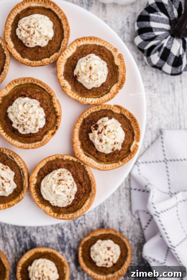Beautifully arranged holiday pies, including individual pumpkin pies, for a festive fall spread.
