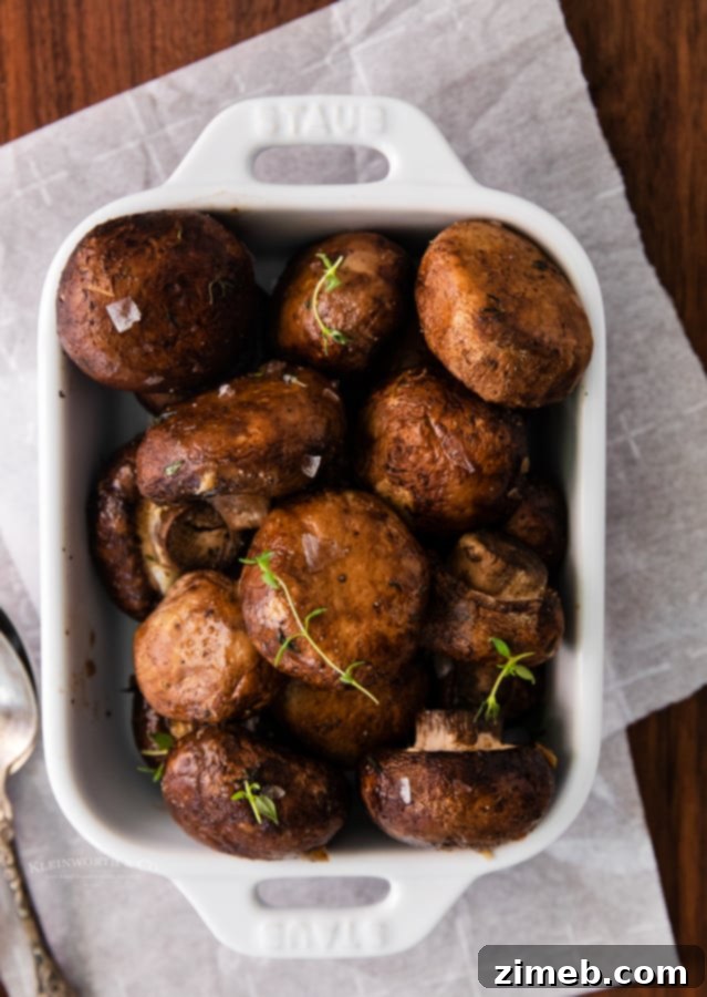 Golden Garlic Thyme Roasted Mushrooms 3 Thanksgiving table with various dishes including a bowl of oven roasted mushrooms with garlic and thyme, perfect for a holiday feast.