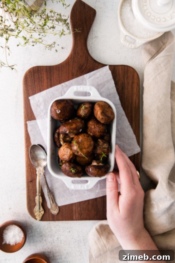 Golden Garlic Thyme Roasted Mushrooms 4 A large bowl of oven roasted mushrooms with garlic and thyme, garnished with fresh herbs, suitable for a holiday side dish or weeknight dinner.