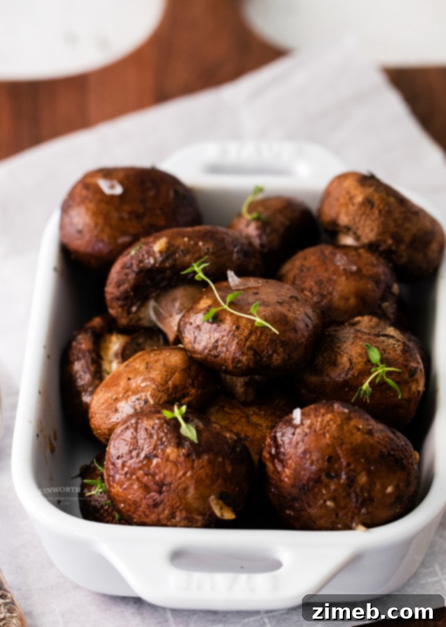 Golden Garlic Thyme Roasted Mushrooms 8 A serving dish filled with perfectly roasted garlic mushrooms, glistening and seasoned, ready to be devoured.