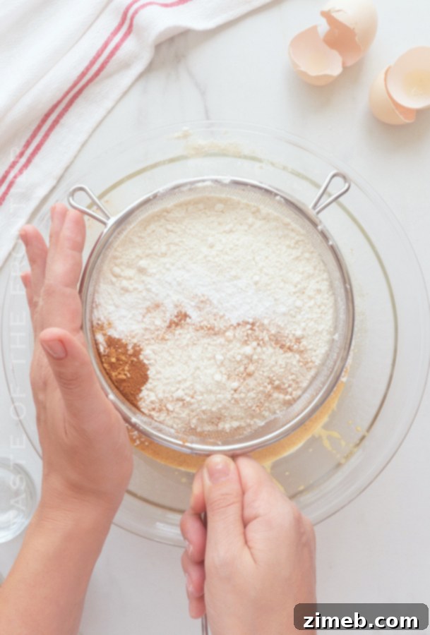 Spiced Ginger Delight 6 Step-by-step process of making Gingerbread Cake, showing the mixing of wet and dry ingredients in a bowl.