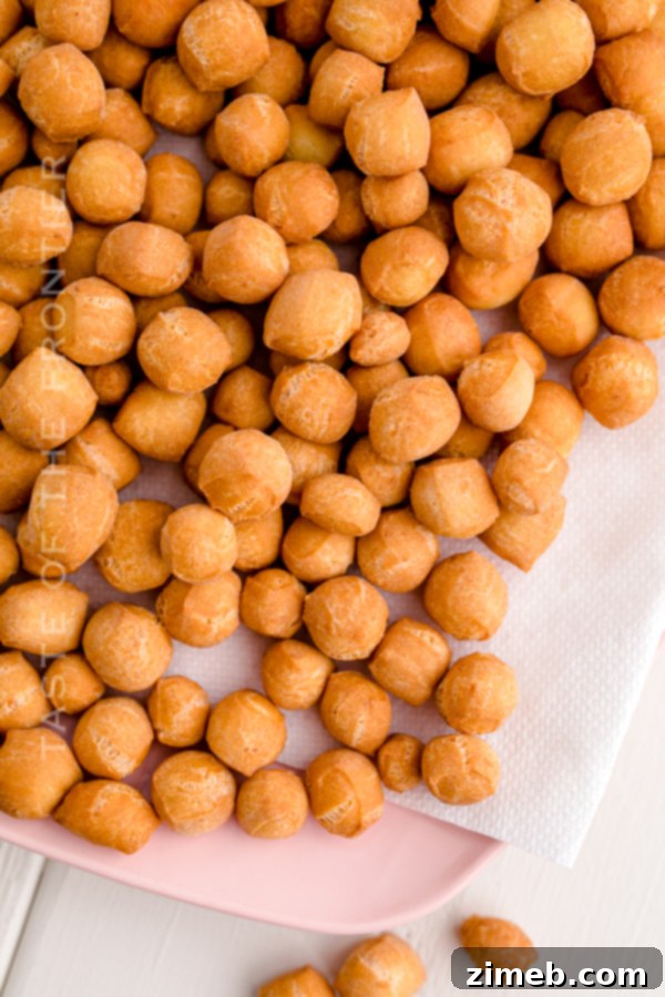 A festive pile of golden, cooked Struffoli on a white plate