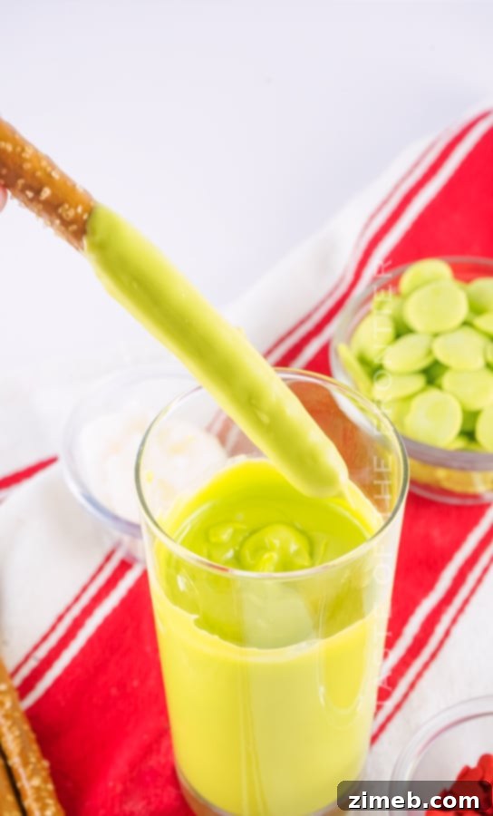 Grinch's Heart-Melting Pretzel Delights 7 Dipping Grinch Pretzels in green chocolate for holiday dessert