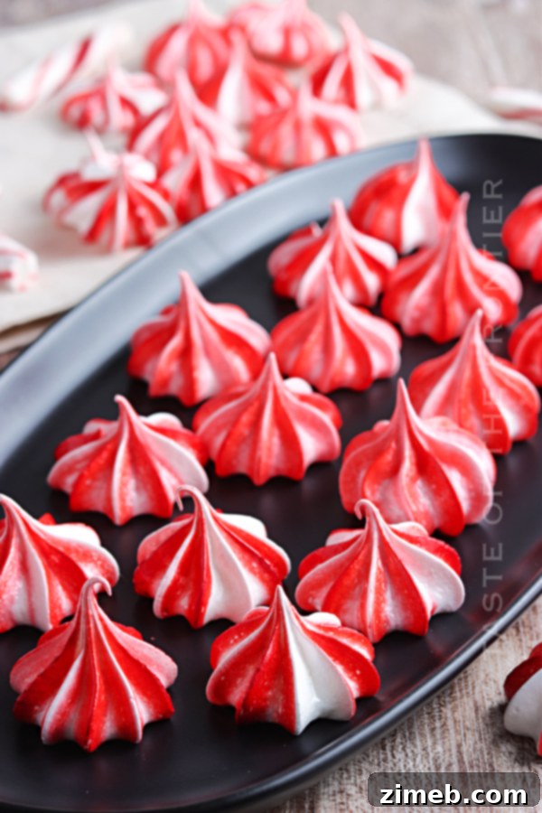 Effortless Meringue Clouds 9 Red and white peppermint meringues on a tray