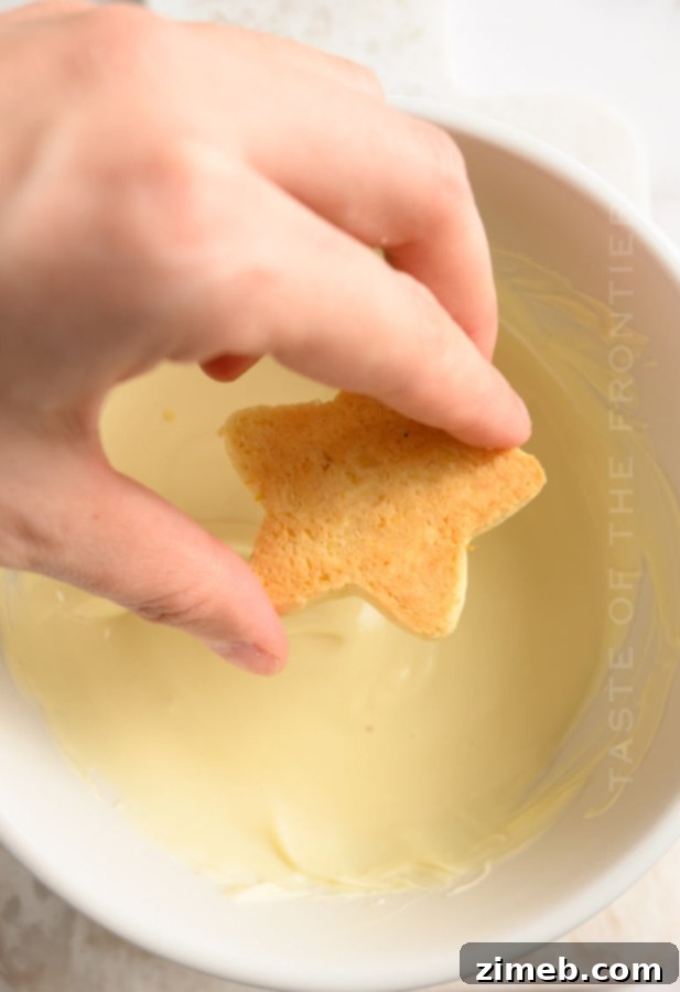 Dipping cookies in white chocolate, showing how to decorate Pistachio Christmas Cookies