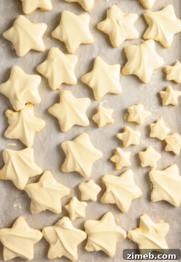 Star cookies coated in white chocolate and pistachios, resembling pistachio shortbread cookies