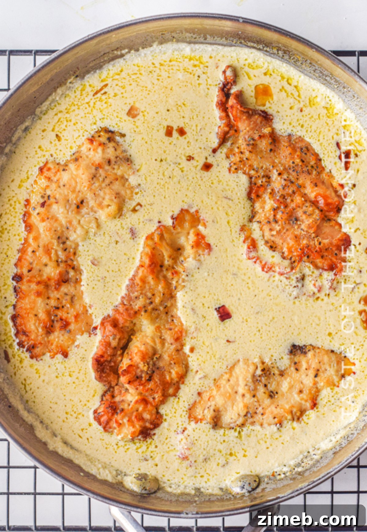Dreamy Creamy Air Fryer Garlic Chicken 9 Air-fried chicken breast coated in creamy garlic sauce, garnished with parsley.