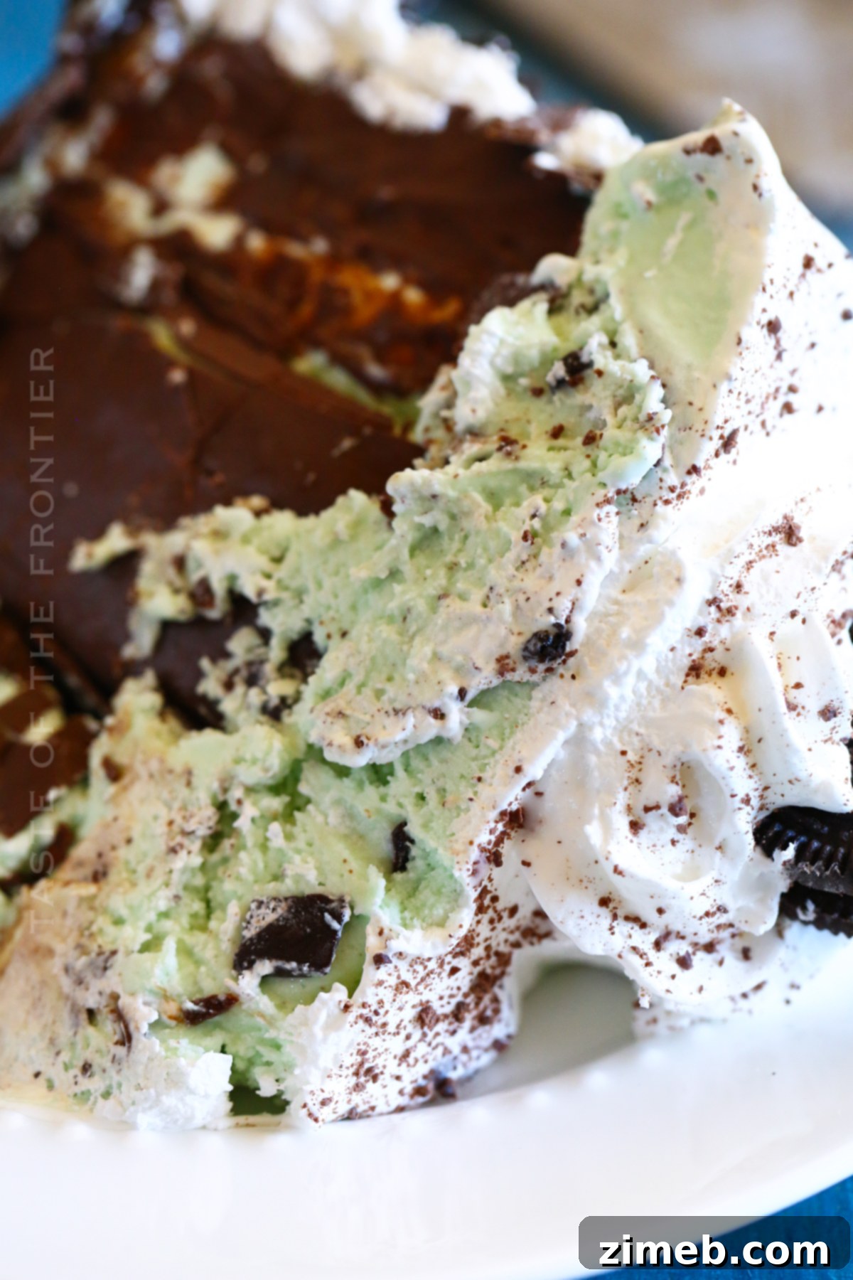 Refreshing Mint Chocolate Chip Ice Cream Cake 10 Whipped topping being applied to ice cream cake