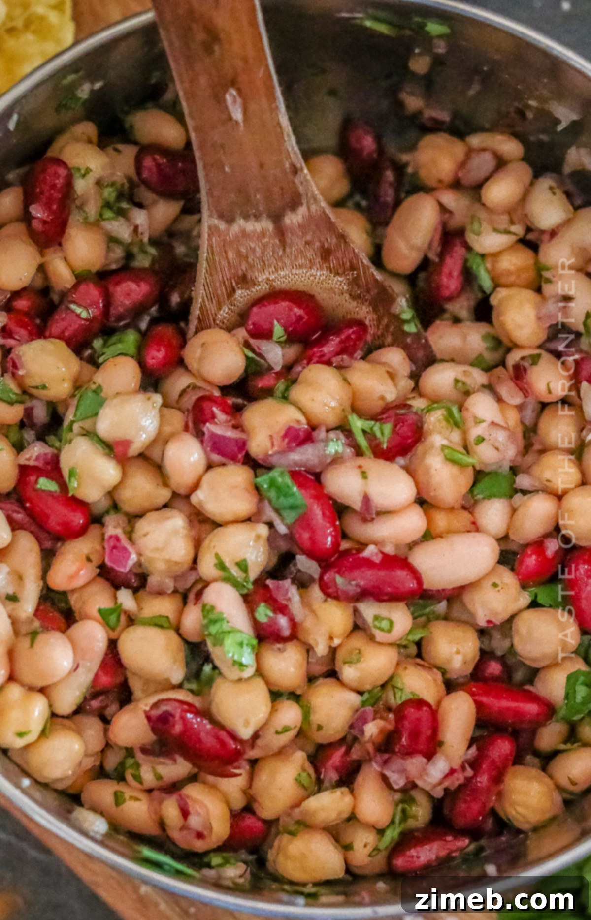 A large serving bowl filled with a fresh, colorful 3 bean salad.