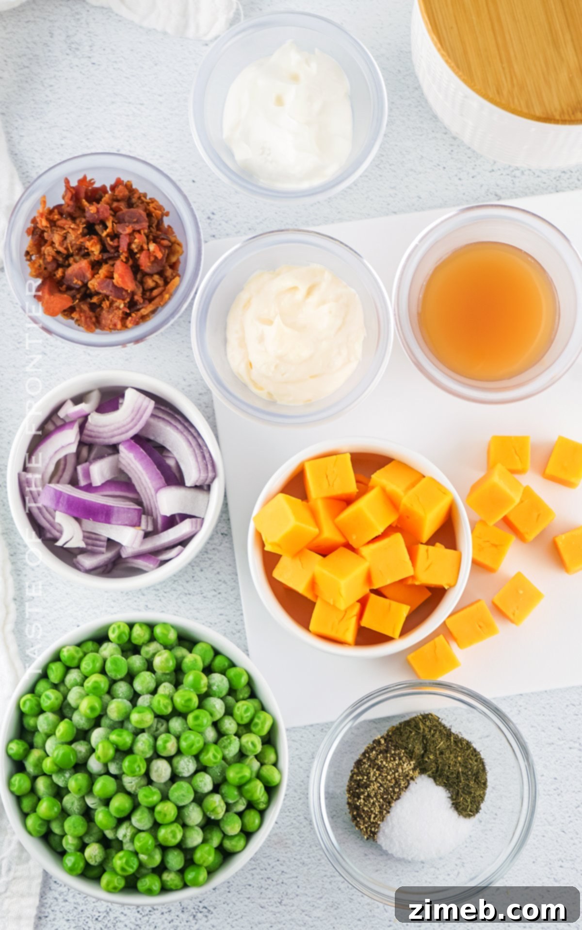 Refreshing Pea Salad 5 All the fresh ingredients for Green Pea Salad laid out on a wooden cutting board.