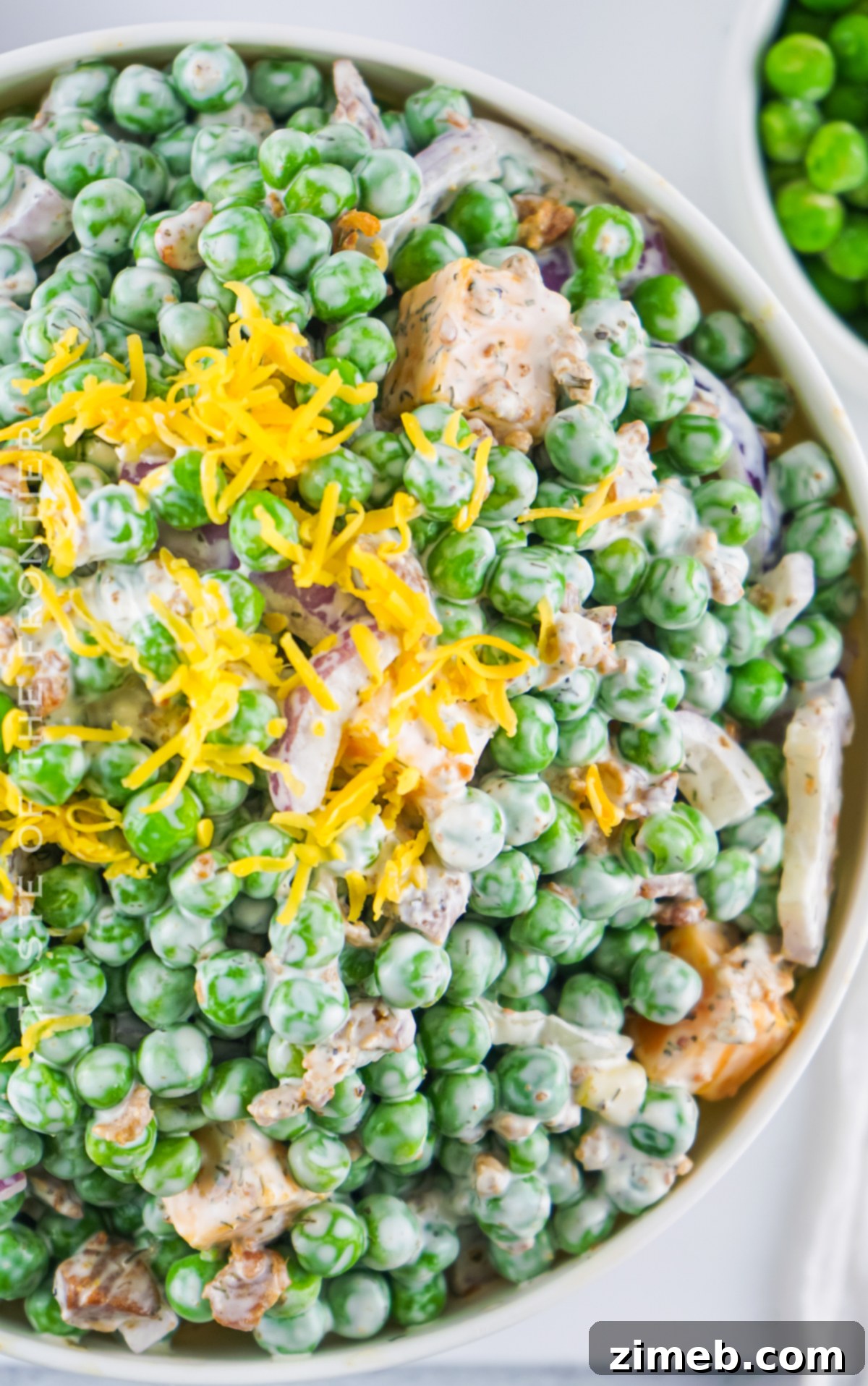 Refreshing Pea Salad 8 A vibrant and colorful recipe for Green Pea Salad, presented in a clear bowl.
