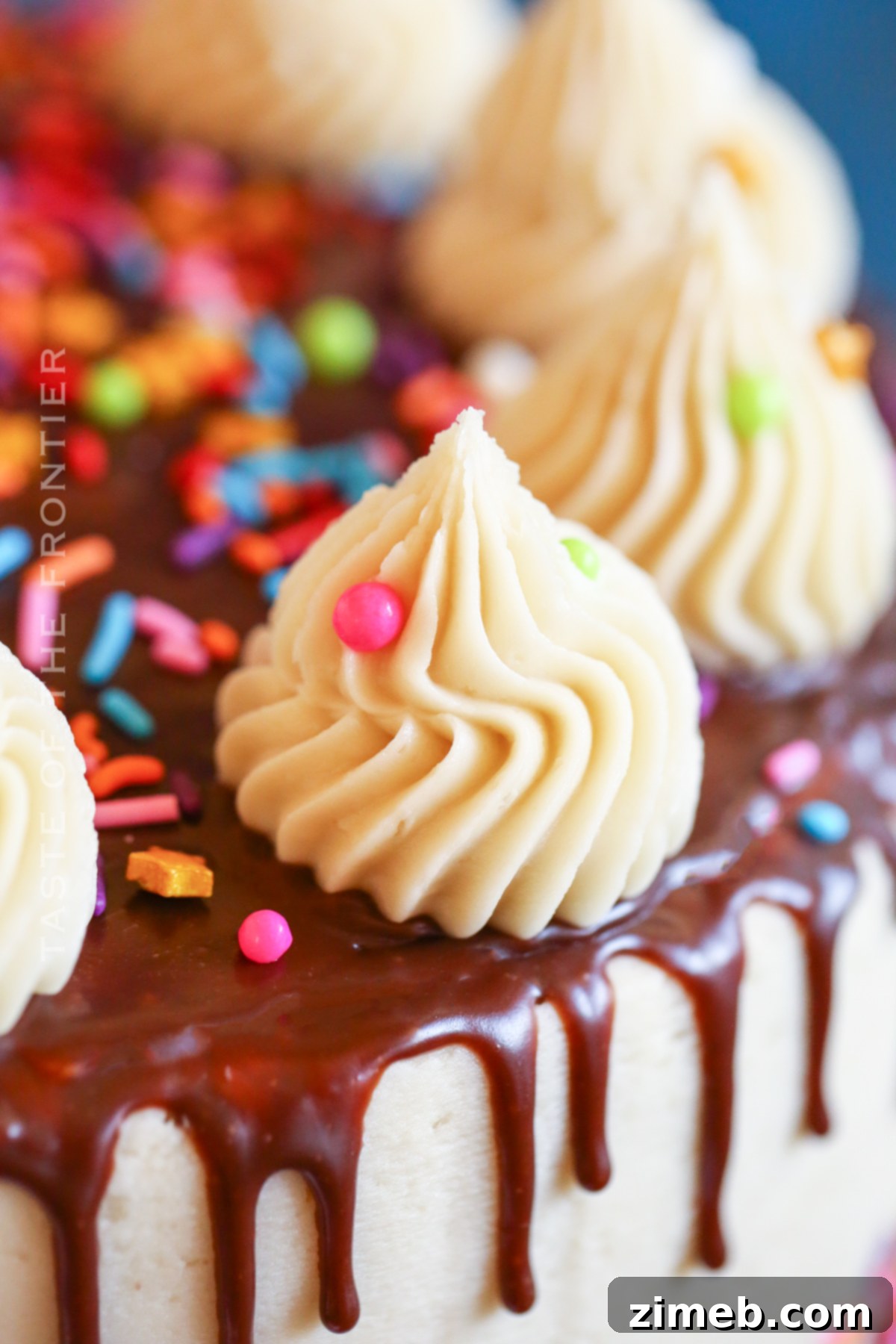 A festive drip birthday cake with a vibrant ganache and colorful decorations.