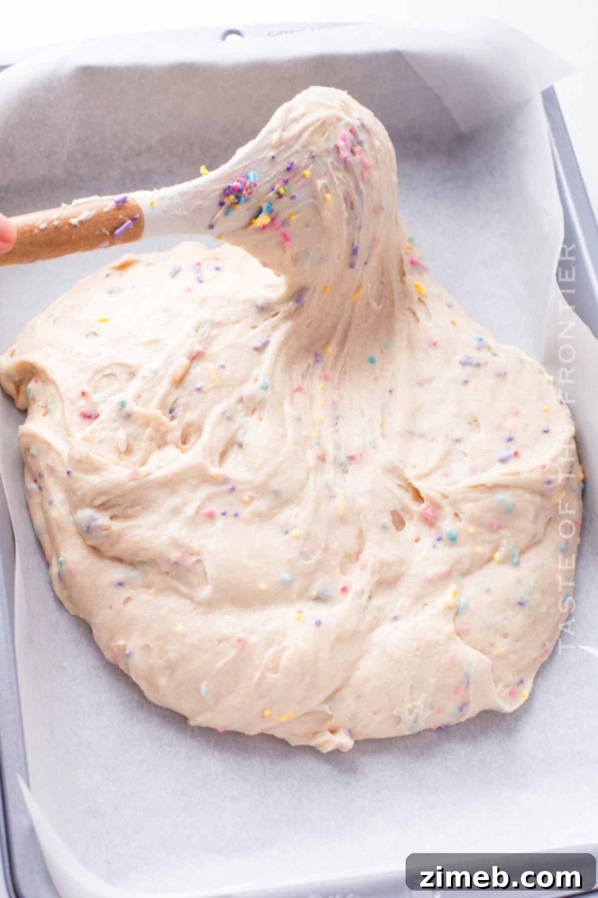 Sprinkle Explosion Cake 8 Spreading Funfetti cake batter in a baking pan