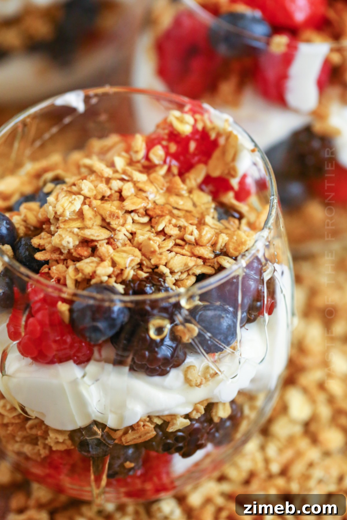 Premium Layered Dessert Glasses 10 A close-up of granola, berries, and honey, highlighting the fresh and natural ingredients in a parfait.