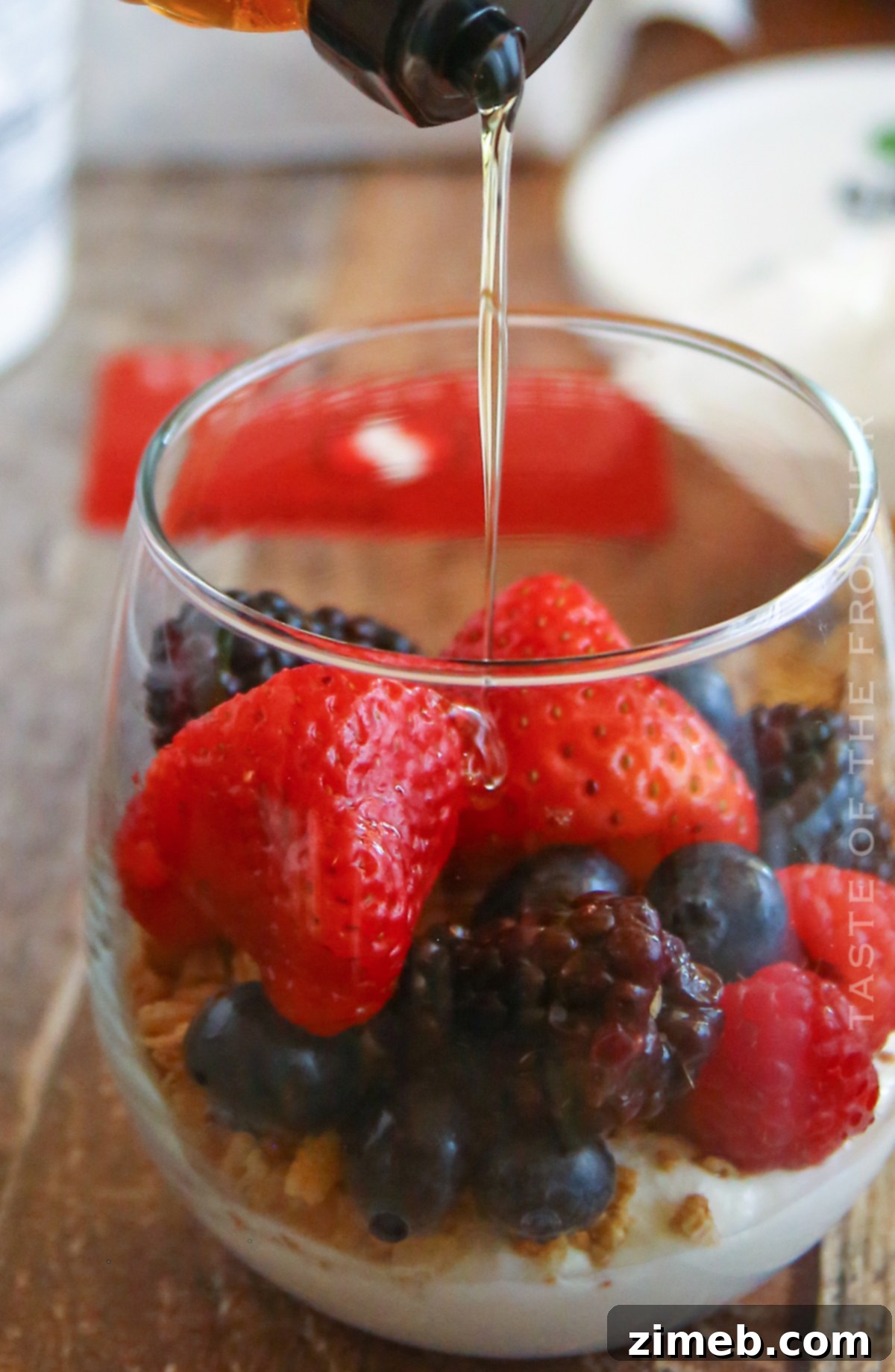 Premium Layered Dessert Glasses 8 Honey being drizzled over creamy yogurt, a step in making delicious parfait cups.