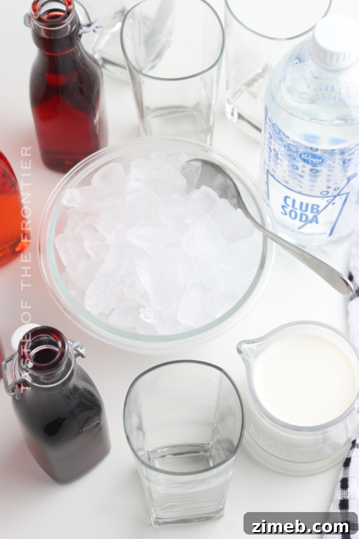 Essential ingredients for making a homemade Italian Cream Soda: crushed ice, flavored syrup, half-and-half, and club soda.