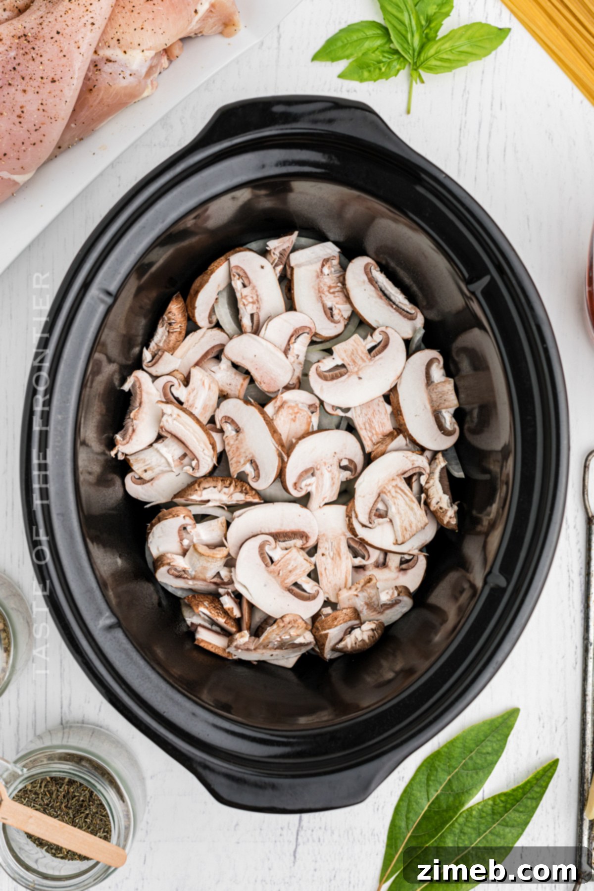 Effortless Slow Cooker Chicken Parmesan 5 Chicken and mushrooms layering in the slow cooker