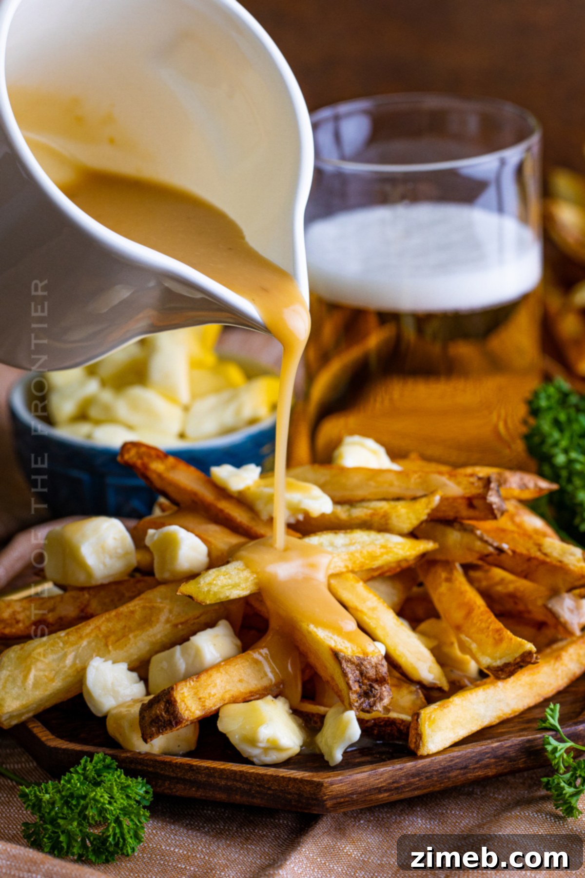 Poutine: Canada's Cheesy, Gravy-Laden Delight 9 Rich gravy poured generously over crispy french fries in a bowl