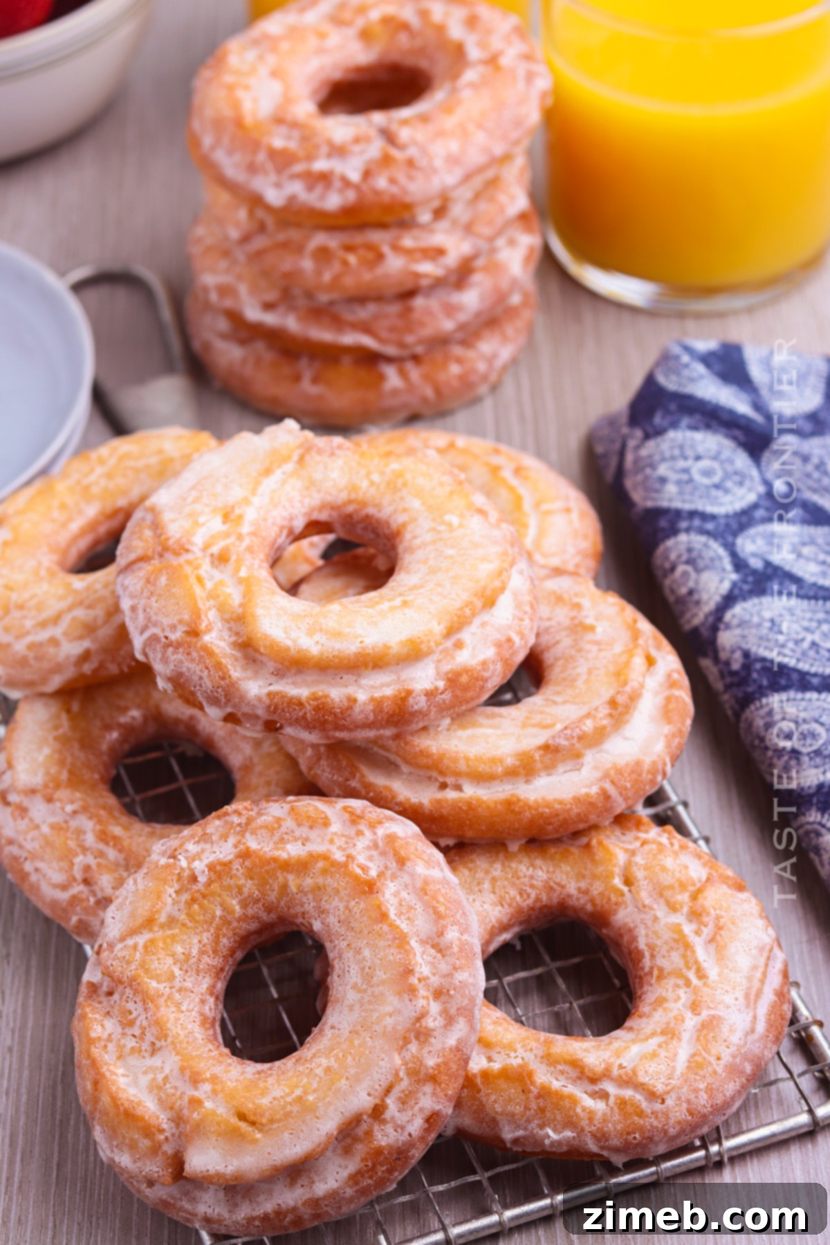 Grandma's Sour Cream Donuts 3 Freshly glazed Sour Cream Donuts on a cooling rack