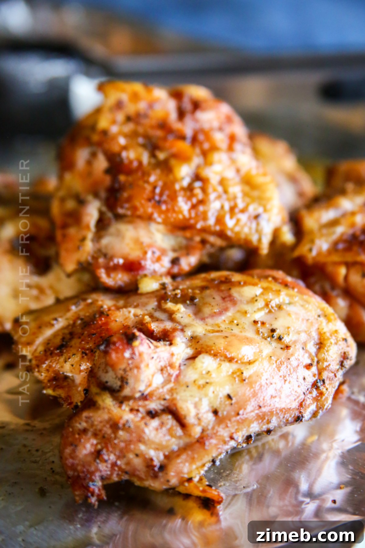 Juicy Smoked Chicken Thighs 6 A close-up shot of juicy smoked chicken thighs on a pellet grill, showing the perfect char and moisture