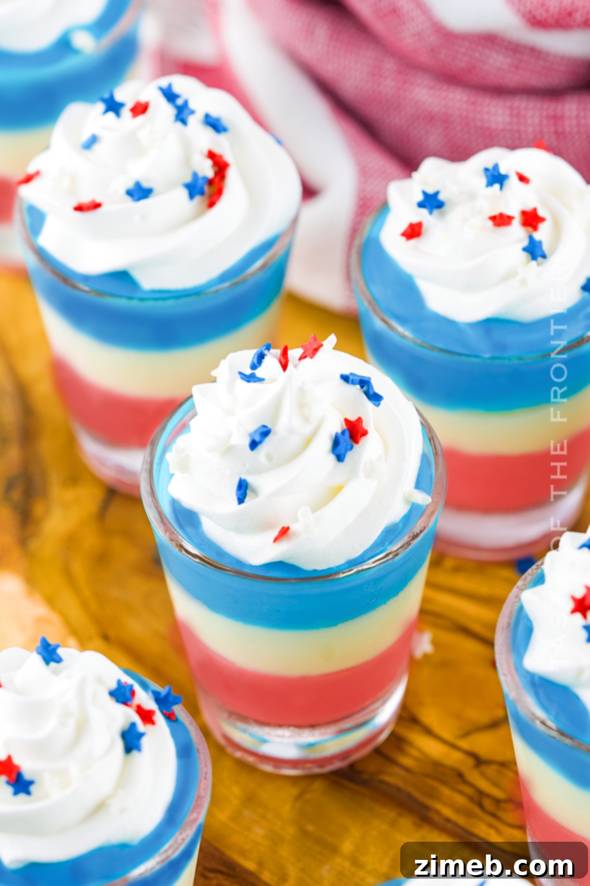 Boozy Pudding Delights 19 4th of July Pudding Shots, layered in red, white, and blue, perfect for festive celebrations.