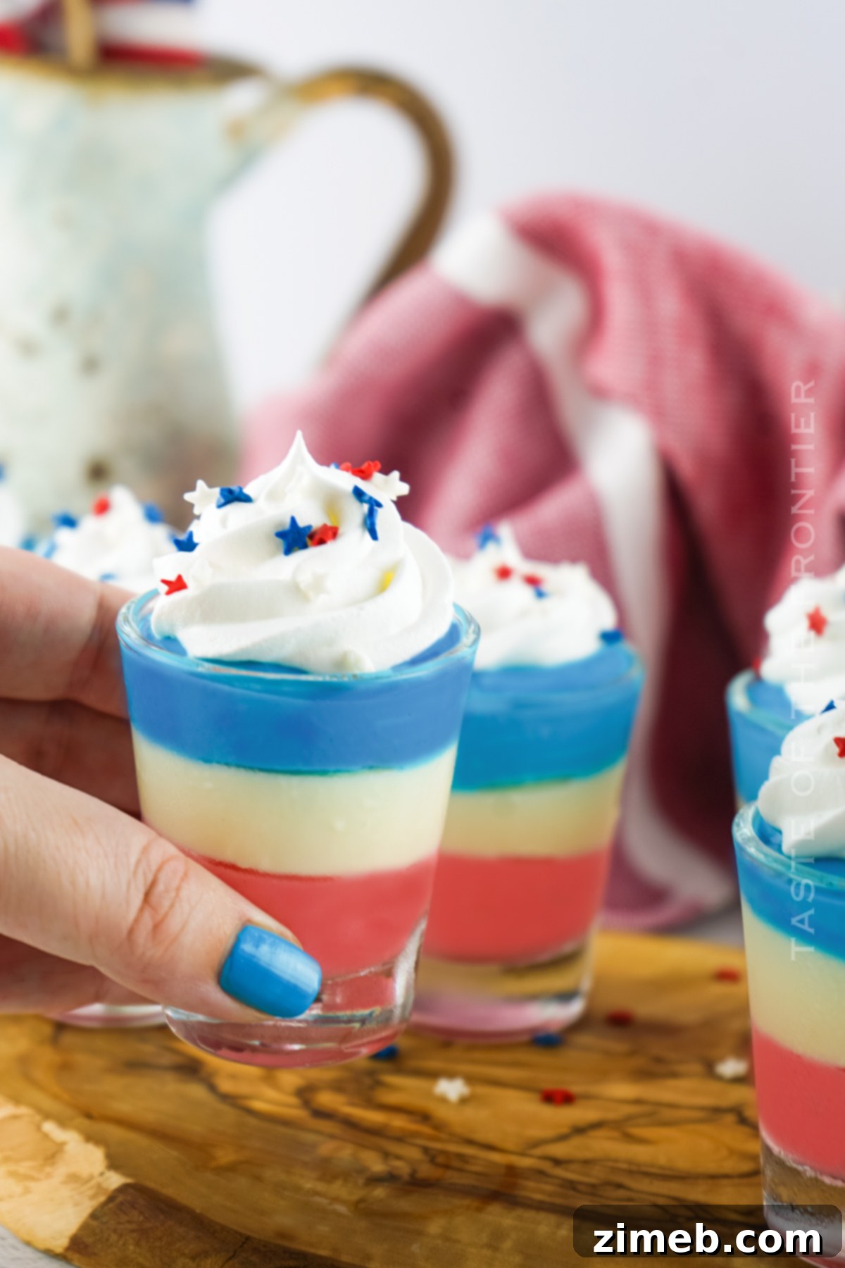 Boozy Pudding Delights 21 Holiday adult pudding recipe, showcasing the layered red, white, and blue cheesecake pudding shots.