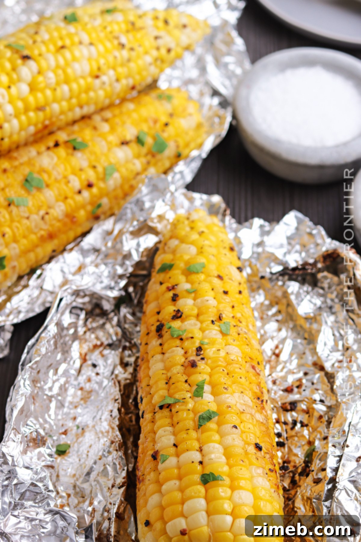 Deliciously Simple Grilled Corn 9 Grilled corn in foil packets on a hot grill