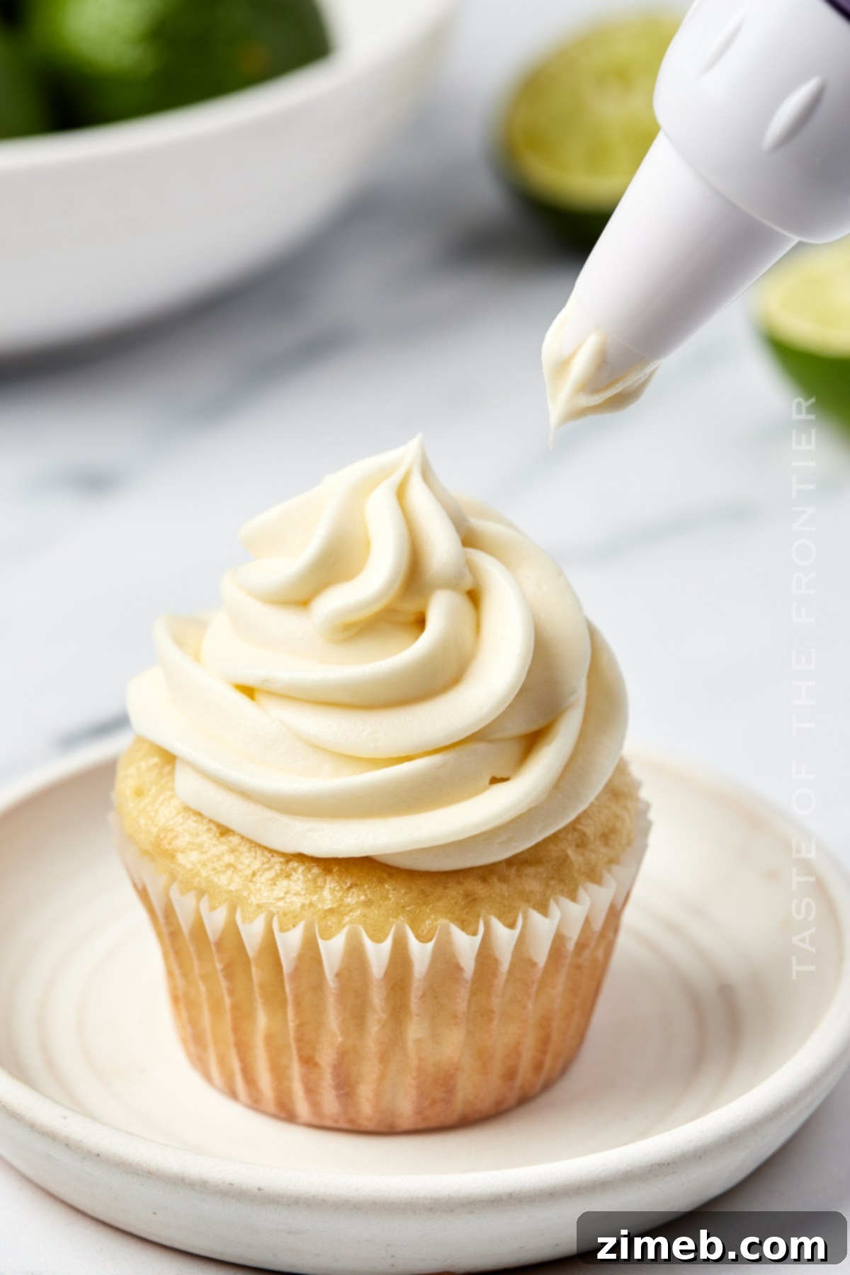 Effortless Coconut Cupcakes 8 adding lime frosting