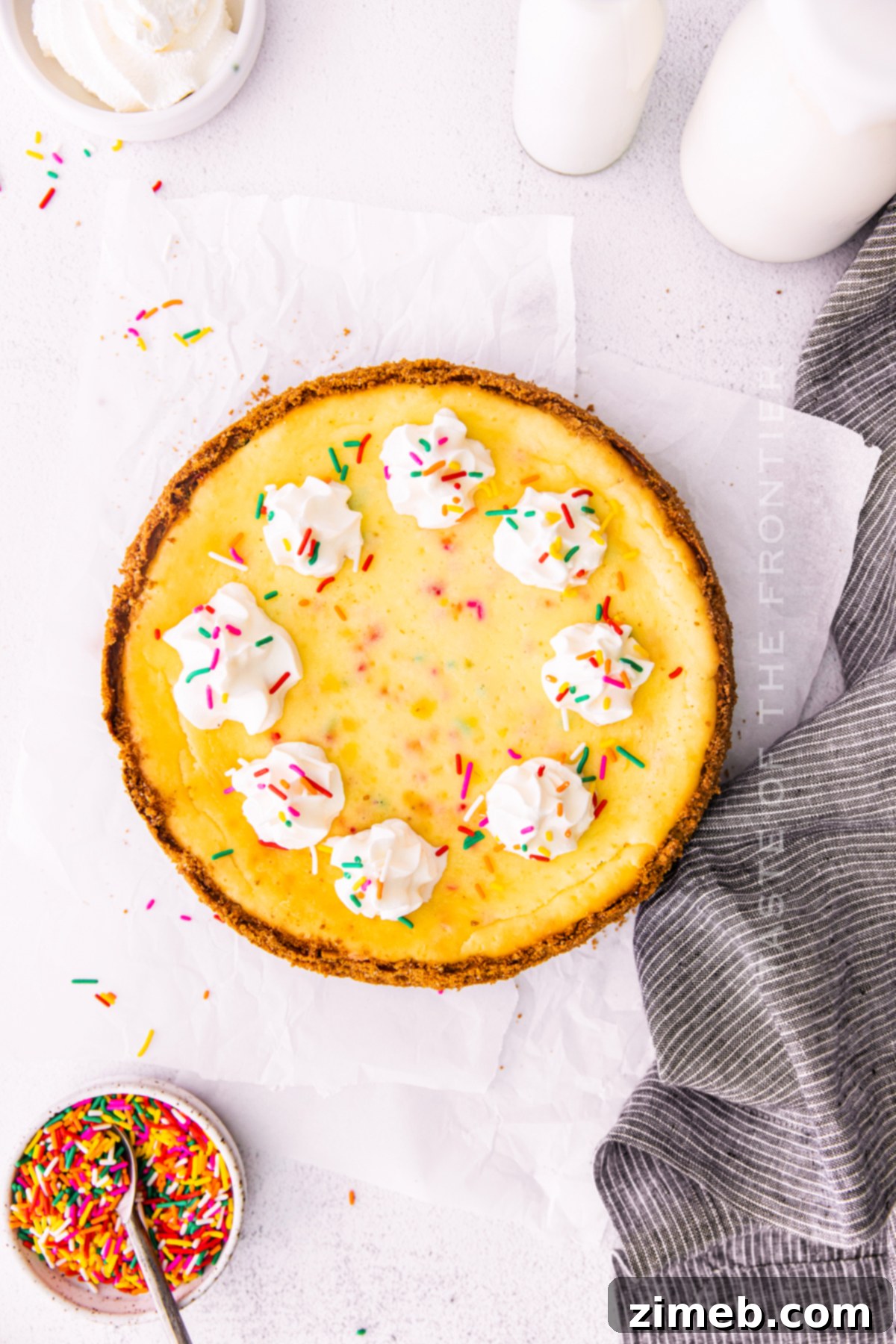 Birthday Bliss Cheesecake 3 Close-up of a perfectly baked Birthday Cheesecake, showcasing its smooth texture and scattered Funfetti sprinkles.