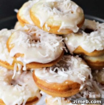 Breakfast recipe for Banana Coconut Donuts with glaze and shredded coconut.