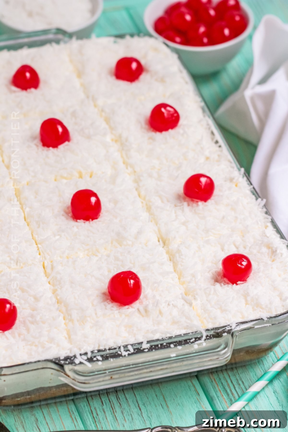 Tropical summer cake with coconut flakes and a cherry, ready to be served.