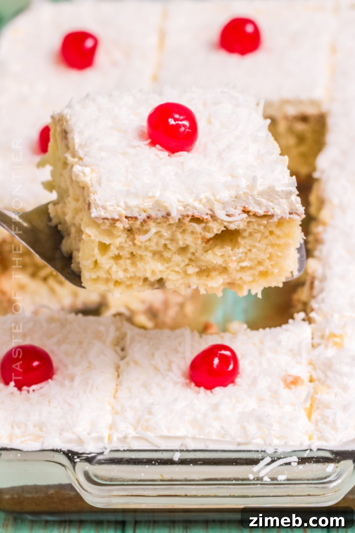 A perfectly cut slice of moist Coconut Poke Cake on a plate.